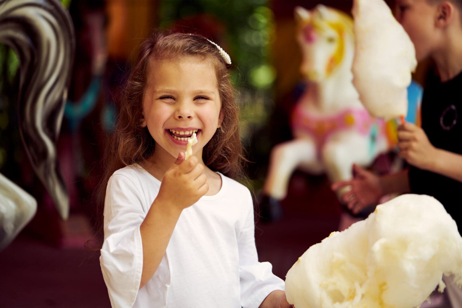 A little girl is smiling and holding her tooth brush.